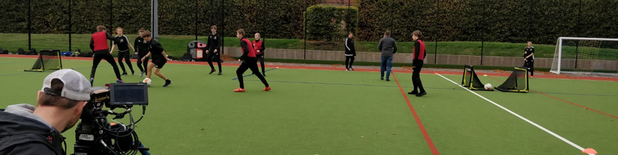 people playing football being filmed